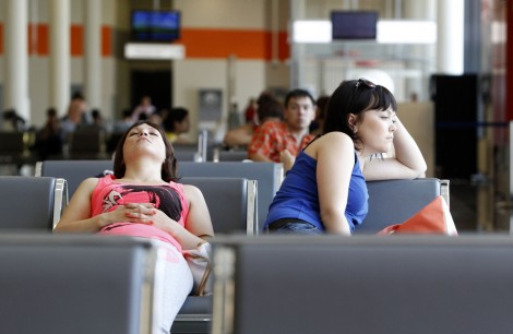 People sit in a waiting room at Moscow's Sheremetyevo airport June 26, 2013. Ecuador said on Wednesday the United States must "submit its position" regarding Edward Snowden to the Ecuadorean government in writing as it considers the former U.S. spy agency contractor's request for asylum. Snowden, 30, a former employee of the U.S. contractor Booz Allen Hamilton, appears to be still in hiding at a Moscow airport awaiting a ruling on his asylum request from the tiny South American nation's leftist government. REUTERS/Sergei Karpukhin (RUSSIA - Tags: POLITICS SOCIETY TRANSPORT)
