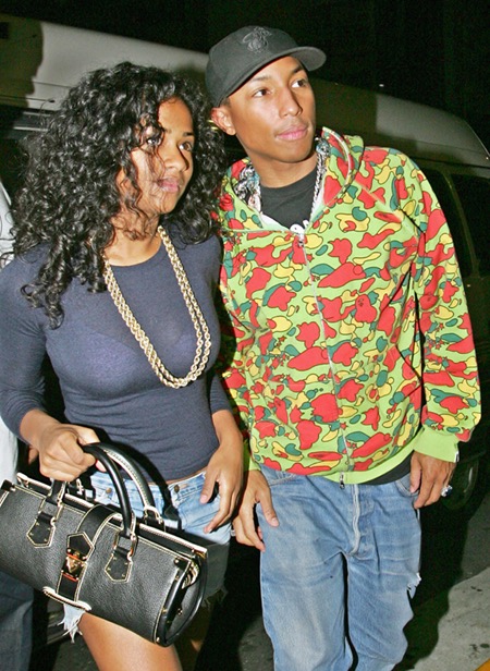 TOKYO, JAPAN: Hip-hop star Pharrell Williams (R) and an unidentified woman arrive at the Warehouse to hold his exclusive live performance as part of the Ice Cream Store opening party in Tokyo, 05 November 2005. Williams is here to promote his Ice Cream sneakers in collaboration with 'A Bating Ape' producer Nigo at the Ice Cream Store. AFP PHOTO/Kazuhiro NOGI (Photo credit should read KAZUHIRO NOGI/AFP/Getty Images)